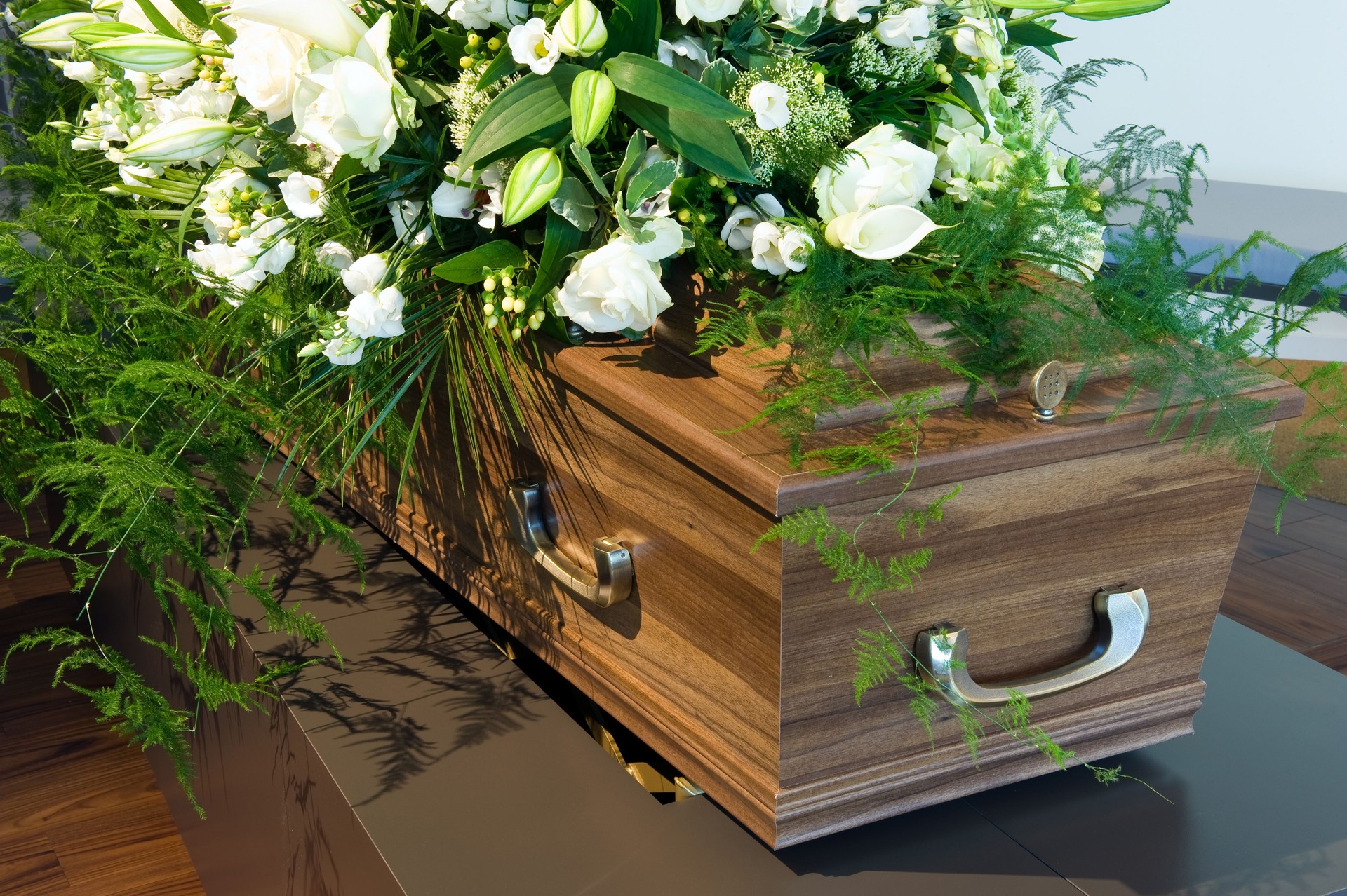 Wooden Coffin in a morgue with white flowers