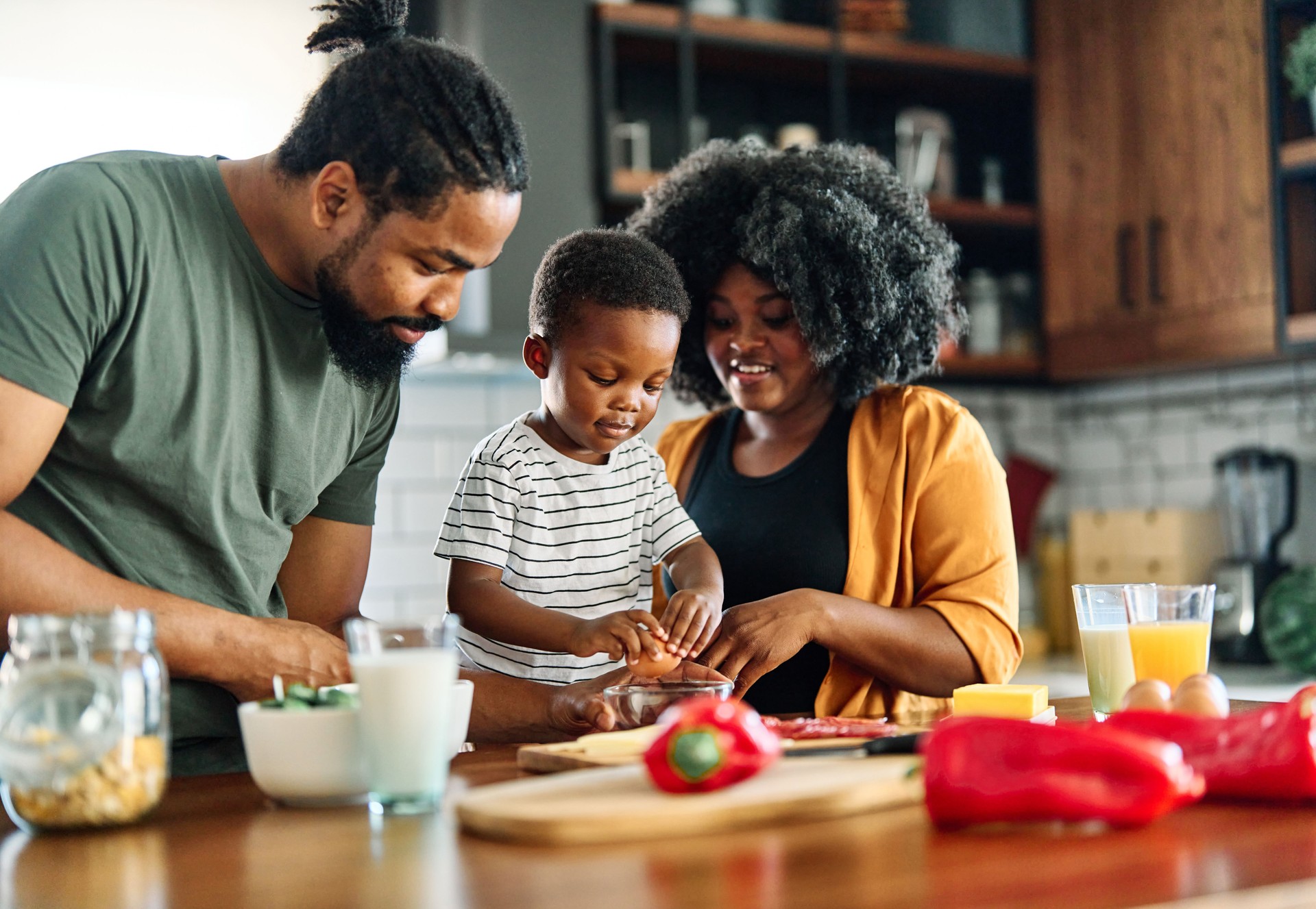 child family kitchen food boy son mother father breakfast preparing egg morning healthy diet eating home black african american father cooking parent cute meal kid